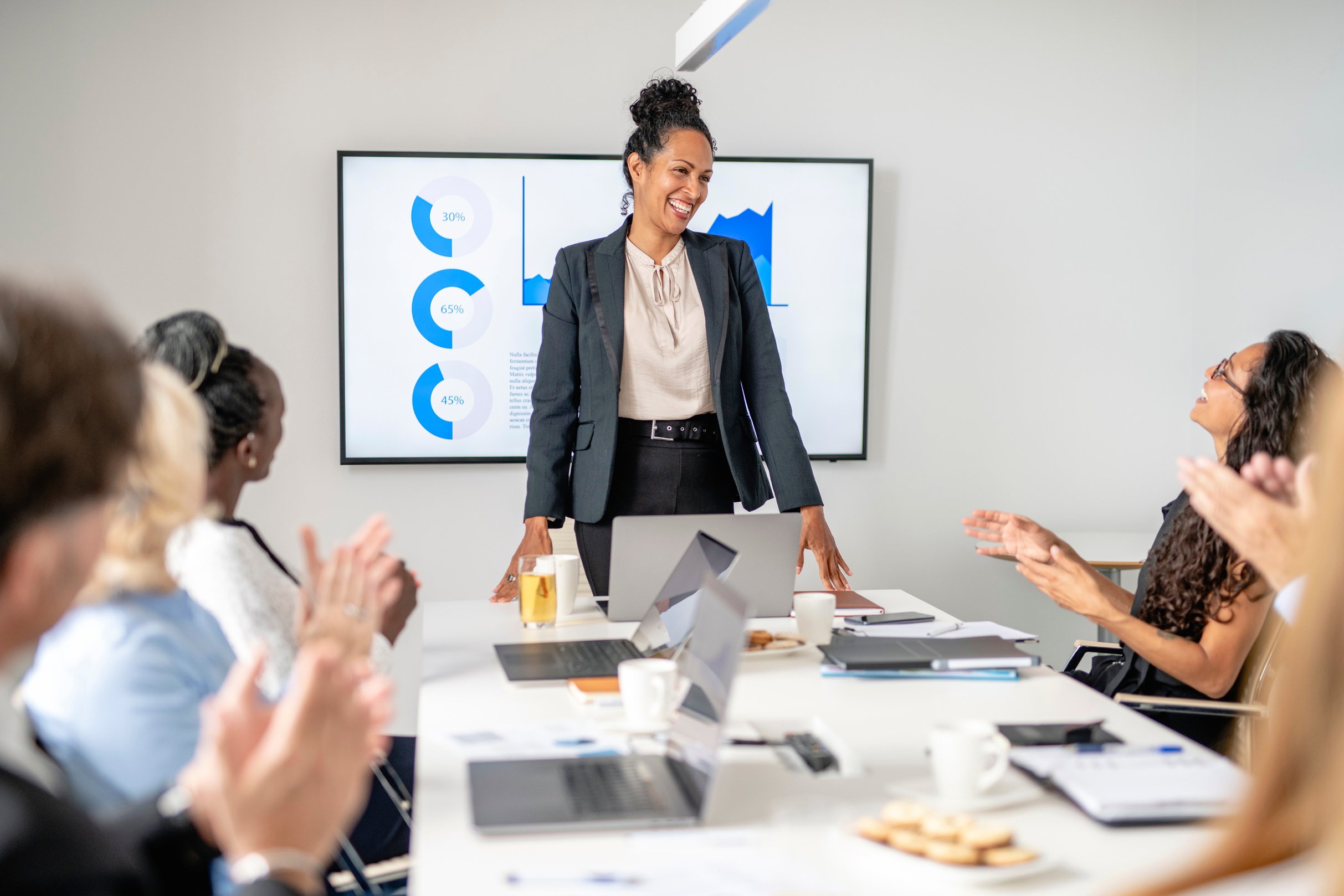 Multi-Ethnic Executive Team Applauding Female CEO in Meeting